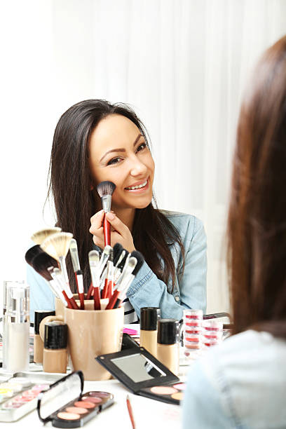 istock Beautiful young woman making make-up 2205572978
