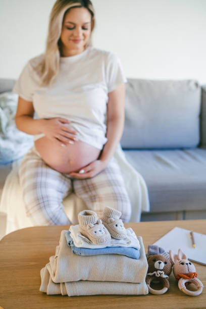 istock Young beautiful woman is packing her maternity bag. 2205573343