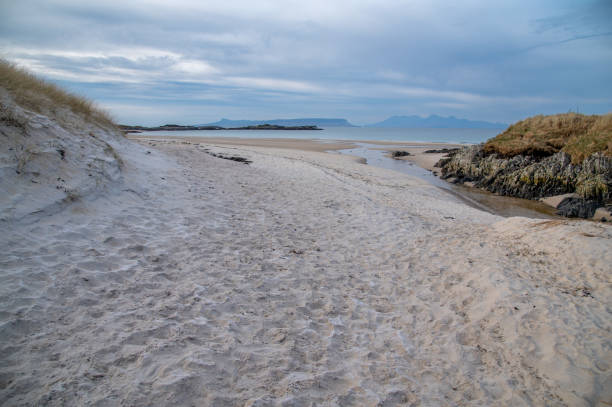 Camusdarach beach is on the Morar peninsula in the Scottish Highlands.  Located south of the town of Morar, the beautiful bay was made famous when scenes from the film Local Hero were shot there.  From the beach the islands of Skye, Rum and Eigg can all be seen.  Photo taken in winter sunlight, in February.