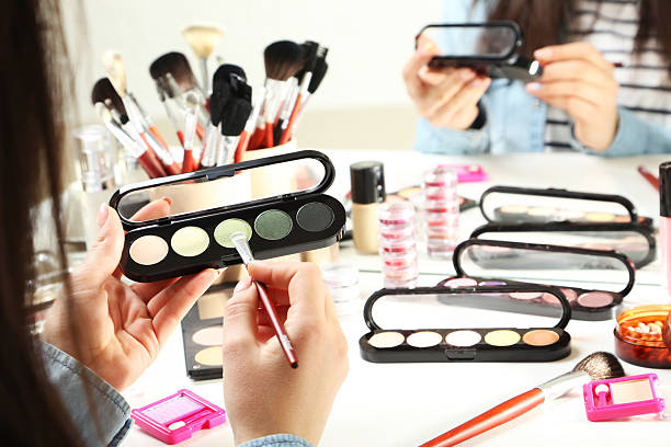 istock Beautiful young woman making make-up 2205574095