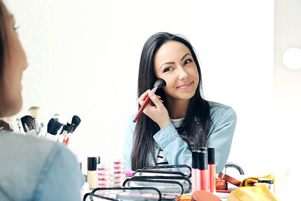 istock Beautiful young woman making make-up 2205574974