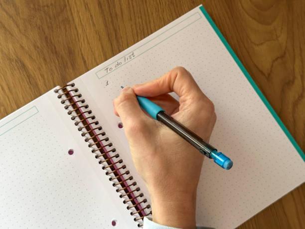 istock Close-up of hand writing the first task in a to-do list notebook 2205575177