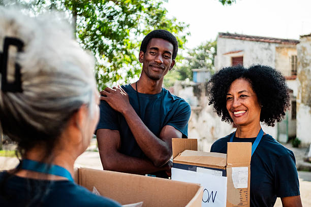 istock Volunteers talking and holding donation boxes outdoors 2205575279