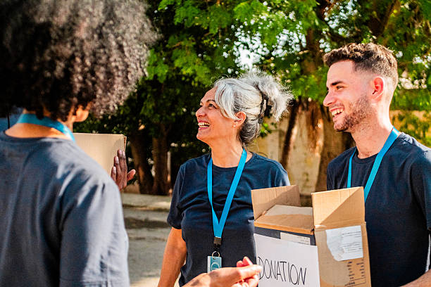 istock Volunteers talking and holding donation boxes outdoors 2205575300