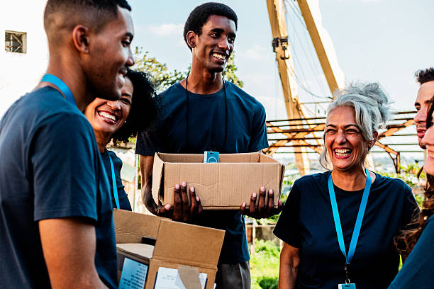 istock Volunteers talking and holding donation boxes outdoors 2205575350