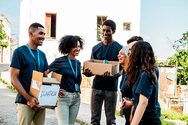 istock Volunteers talking and holding donation boxes outdoors 2205575388