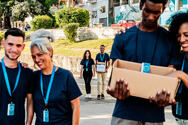 istock Volunteers walking and holding donation boxes outdoors 2205575389