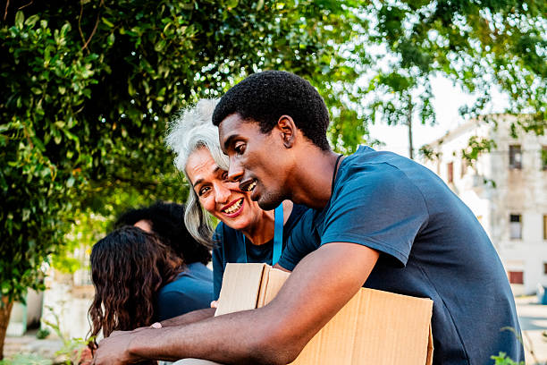 istock Volunteers talking and holding donation boxes outdoors 2205575428