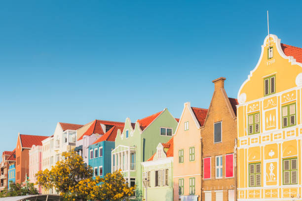 Warm, glowing light enhances the vivid hues of the old colonial building, bringing the picturesque city scene to life with a captivating blend of color and charm. Upper section of the building facades.