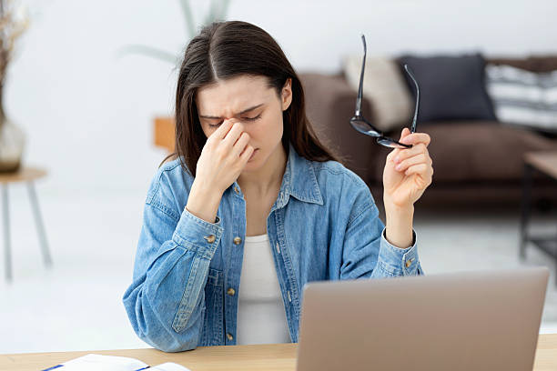 istock Tired young woman working on laptop 2205581932