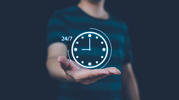 istock Nonstop service 24 hr concept. Man hand holding virtual 24-7 with clock on hand for worldwide nonstop and full-time available contact of service concept. 2205582498