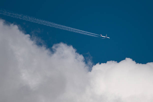 istock Airliner flying over white cumulus in blue sky 2205584300