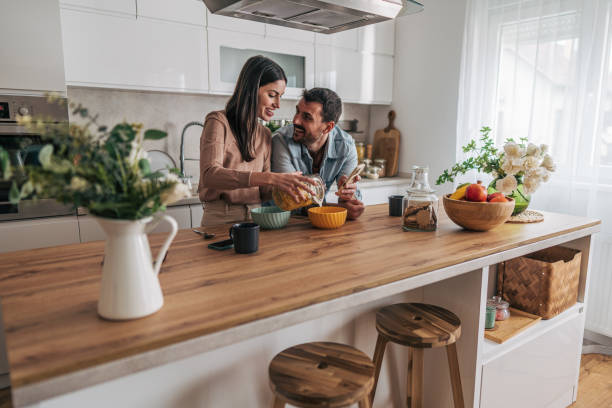 Happy couple preparing breakfast together in modern kitchen