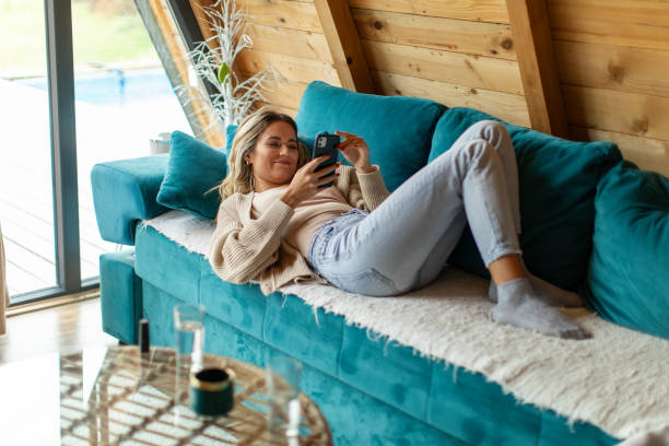 istock Woman using phone in a log cabin 2205586665