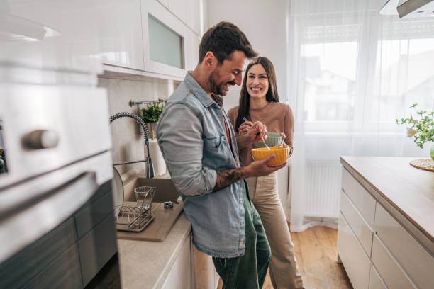 istock Happy couple sharing a meal together in their modern kitchen 2205586711