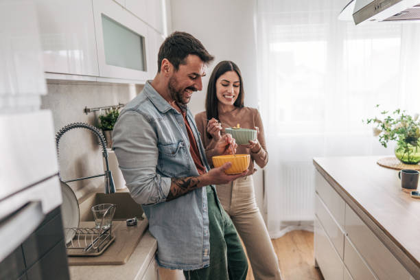 istock Happy couple enjoying a meal together in their modern kitchen 2205586749
