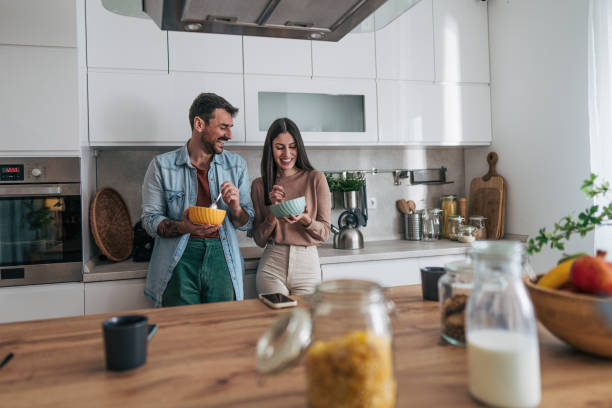 istock Cheerful couple enjoying breakfast together in modern kitchen 2205586915