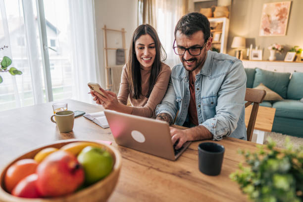 istock Young couple working from home using laptop and smartphone 2205587037