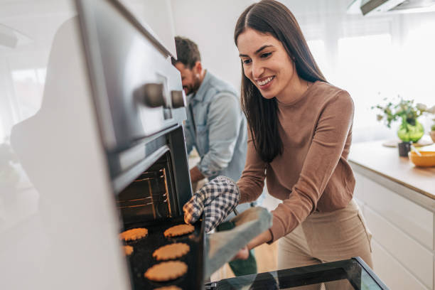 istock Happy couple baking cookies at home in modern kitchen 2205587043
