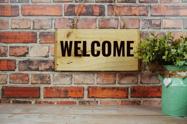 istock Welcome Home text on wooden sign hanging on old brick wall background 2205587458