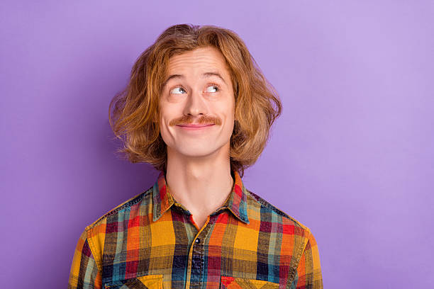 istock Portrait of attractive cheerful funky bewildered guy overthinking copy blank space isolated over bright violet purple color background 2205587597