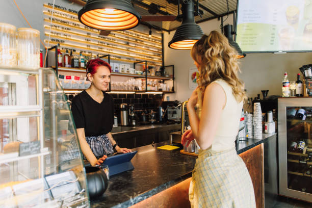 istock Friendly Service: Barista Engages with Customer in a Modern Coffee Shop 2205588068