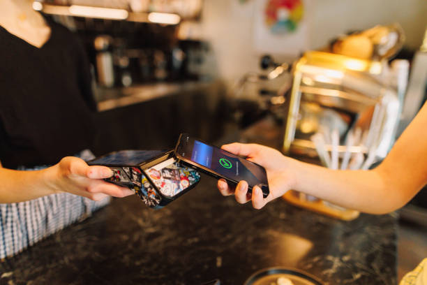 istock Unrecognisable Persone Pays for Her Coffee Shop Order with Smartphone 2205588204