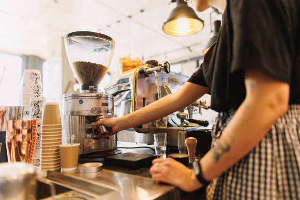 istock Unrecognizable Female Barista Grinding Coffee Beans in Machine 2205588222