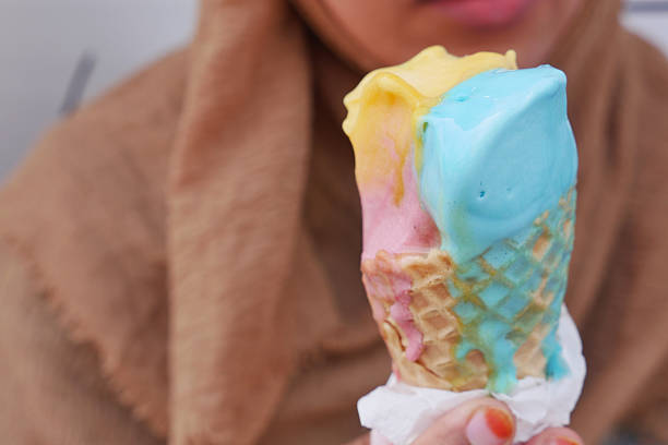 A vibrant ice cream cone featuring blue, pink, and yellow scoops, perfect for summer.
