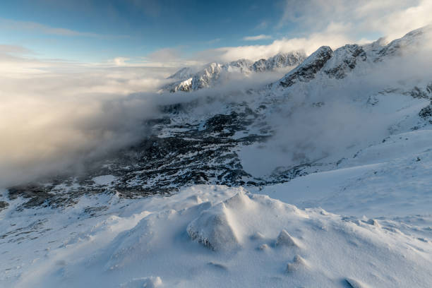 istock Snowy Mountain Peaks and Misty Clouds 2205590040