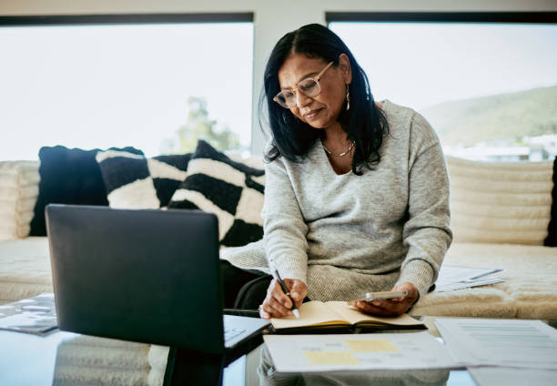 Focused Middle-Aged Woman Working Remotely at Home stock photo