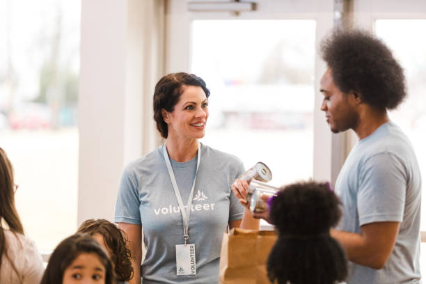 istock Volunteers Sharing Canned Goods, Food Bank Teamwork 2205590295