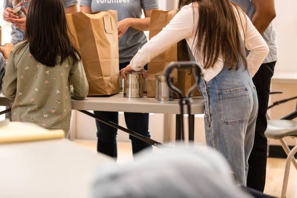 istock Volunteers Sorting Canned Goods at Community Food Drive 2205590304