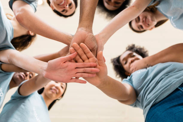 istock Multiracial Group of Volunteers Stacking Hands in Unity 2205590334