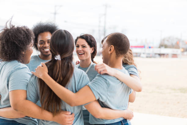 istock Multiracial Group of Volunteers Hugging, Showing Teamwork and Togetherness 2205590335