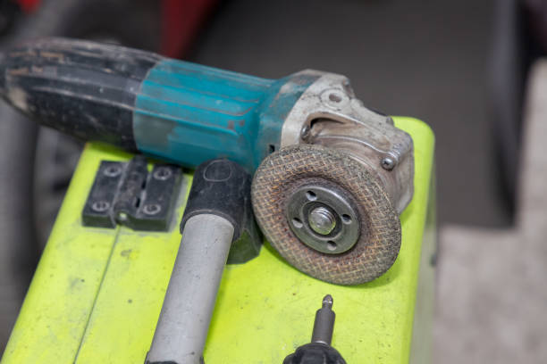 istock Used angle grinder with worn disc on a workbench  heavy-duty power tool for cutting, grinding, and polishing in an industrial workshop or garage 2205590772