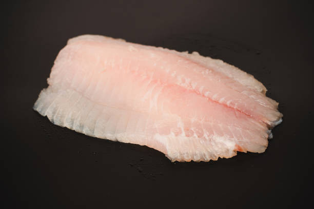 istock Fresh tilapia fillet on black background, top view. 2205591073