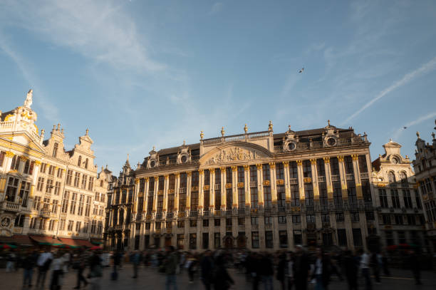 Crowd of tourists walking in the grand place, brussels, belgium, at sunset