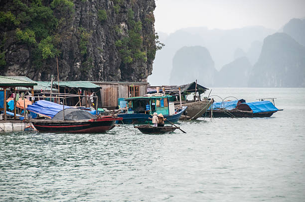 Ha Long Bay, Vietnam - nov 27, 2013: view of floating houses and boats in a floating village  among the pinnacles of Ha Long Bay