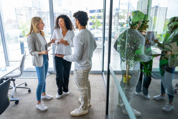 istock Three business people talking meeting while standing in the office 2205596724