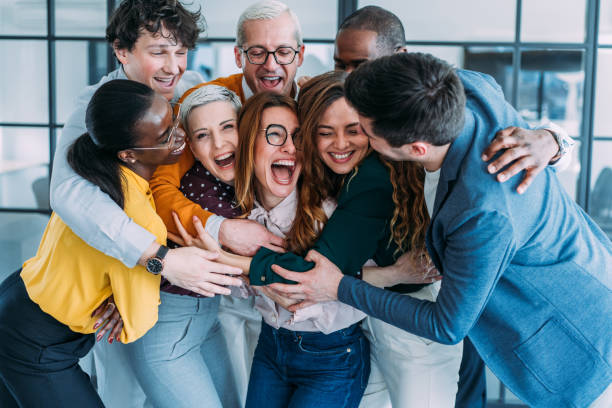 istock Excited coworkers embracing each other during a celebration in the office. 2205598345