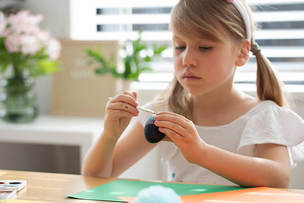 istock Child enjoying creative painting of Easter eggs in sunny room. Happy Easter 2205598820