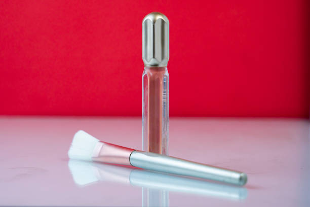 Lip gloss and makeup brush mockup on a white background, great for beauty product showcases and branding.