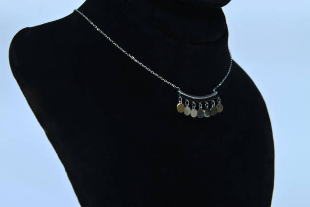 istock A side view of a silver minimal necklace, on a jewelry display bust 2205599417