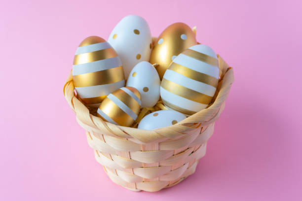 istock A wooden basket filled with decorated easter eggs on a pink background 2205599559