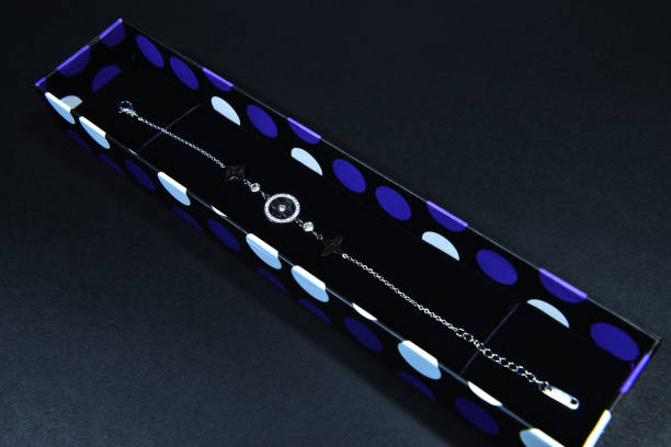 A thin chain silver bracelet, in a gift box on white background