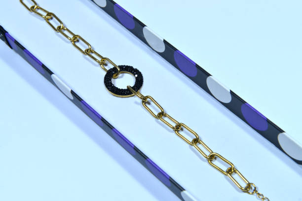 A golden bracelet with a simple and modern design in a gift box on white background