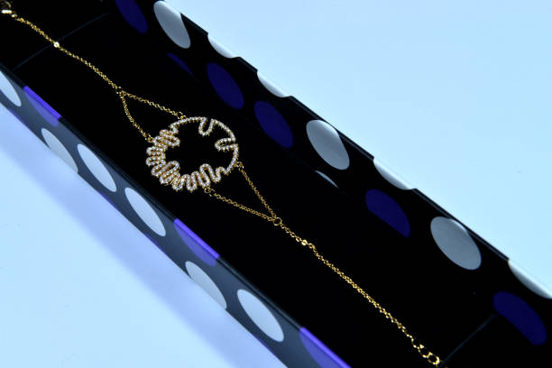 A golden bracelet with a modern design in a gift box on white background