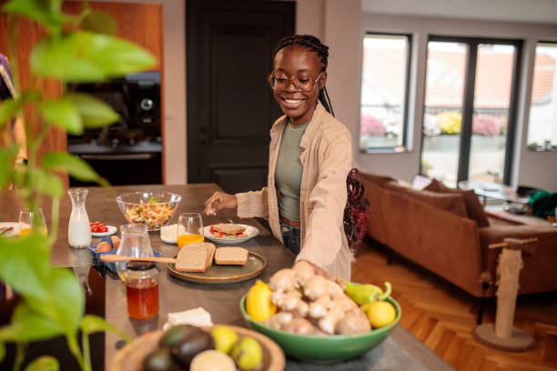 istock Young Woman Making a Sandwich in the Kitchen 2205602079