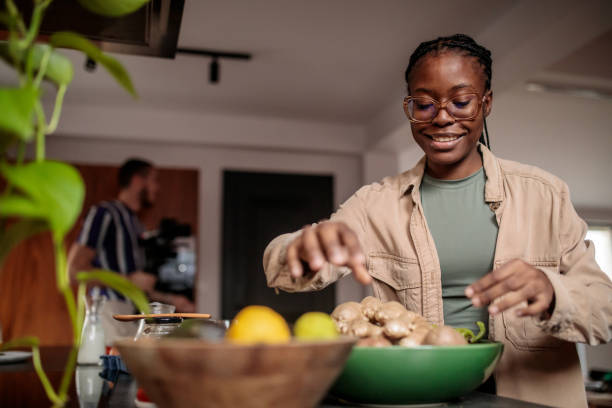 istock Young Woman Taking Ginger from a Bowl 2205602097
